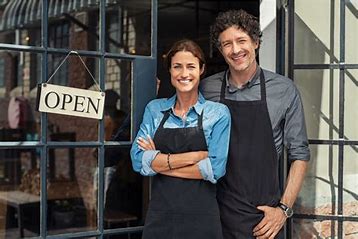 business owners standing in front of an open sign